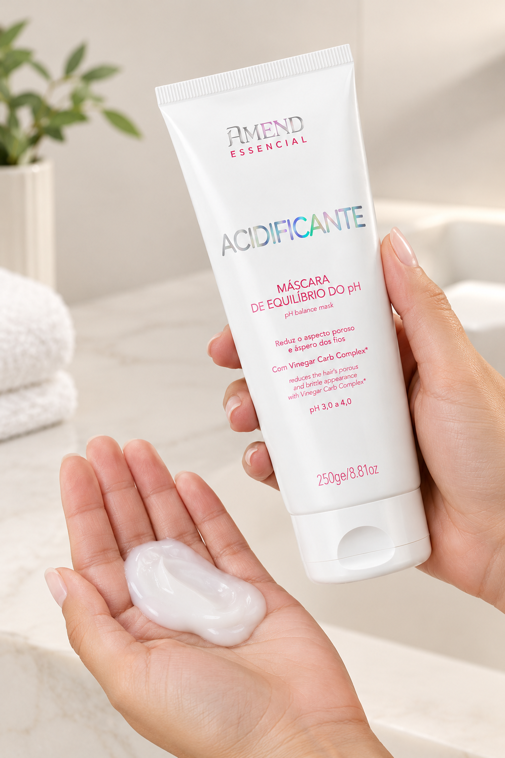 Mãos segurando a bisnaga do Acidificante Amend Essencial Máscara de Equilíbrio do pH 250 g, com uma porção do creme na palma